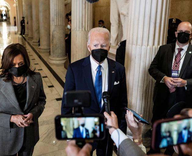 US President Joe Biden, flanked by Vice President Kamala Harris, speaks to reporters in the Hall...