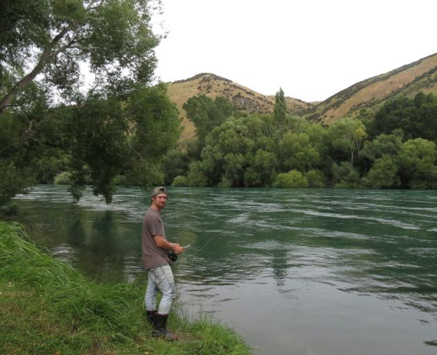 Dunedin resident Brayden Marsh fishes in the Clutha River at the lower boundary of the camping...