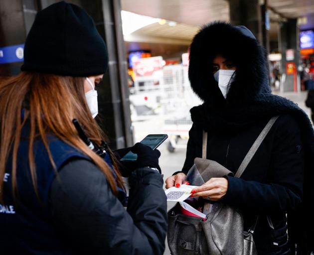 A person shows Covid-19 "Super Green Pass" before getting on a train in Rome on Sunday. Italy...