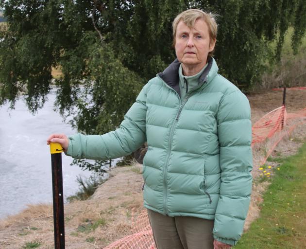 Mataura resident Jenny Soper at the edge of the Mataura River bank beside River St and the safety...