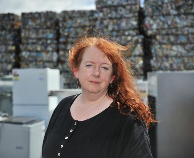 Standing before piles of crushed cans and whiteware is Associate Prof Sarah Wakes, of the...