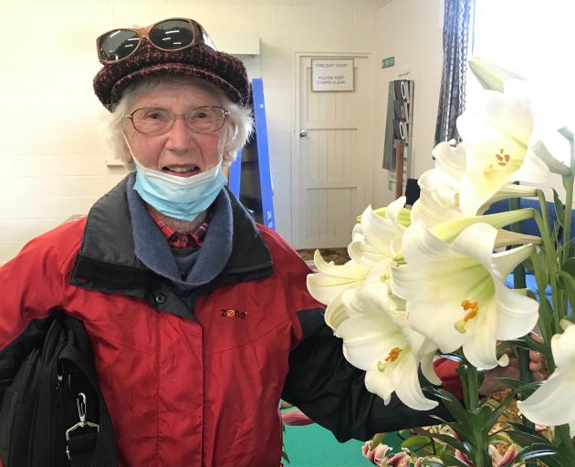 Dorothy Megget, of North East Valley, stands beside her huge Lilium longiflorum that won the...