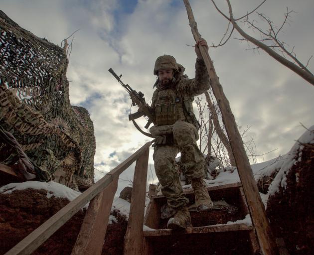 A service member of the Ukrainian armed forces walks at combat positions near the line of...