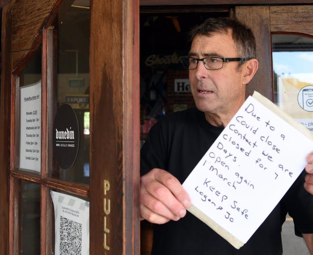 Filadelfio’s Pizza owner Logan Beck puts up the closed sign after a staff member tested positive...