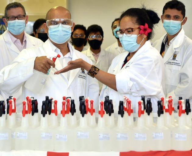 Applying hand sanitiser are Prof Shyamal Das (left) and Dr Losa Moata’nae. From left rear are...