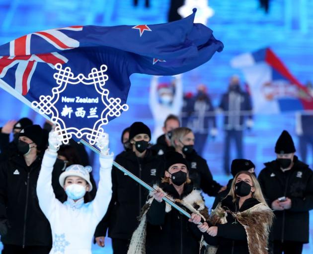 Flag bearers Finn Bilous (left) and Alice Robinson lead the New Zealand team during the Opening...