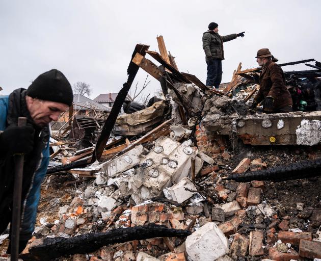 Residents work among remains of a residential building destroyed by shelling in Zhytomyr, Ukraine...