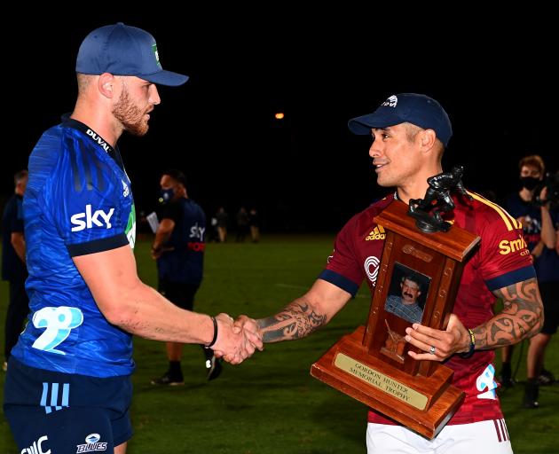 Highlander Aaron Smith hands over the Gordon Hunter Memorial Trophy to Dalton Papalii of the...