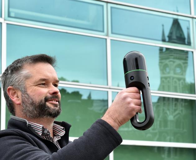University of Otago head of technical services Rob Wilks holds a Leica BLK2GO laser scanner aloft...