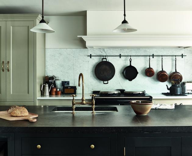 This classic kitchen features a Carrara marble splashback, a blue fossil stone countertop and...