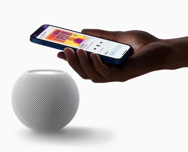 Apple's HomePod mini is seen with an iPhone in a photograph released in Cupertino.  Apple Inc./Handout via Reuters