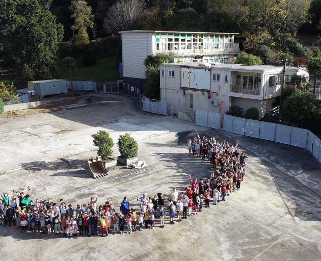 Arthur Street School pupils stand on the site where half their school has been demolished. PHOTO:...