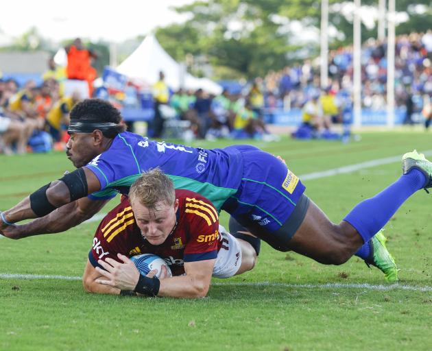 Highlanders winger Sam Gilbert scores a try in the tackle of his Fijian Drua counterpart Vinaya...