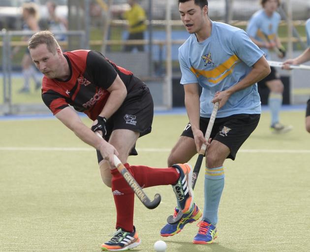 Albany’s Matt Moore flicks the ball past University player Andrew Popham during the Dunedin...