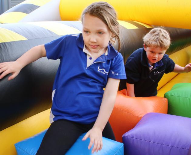 Indie Hewett (6) and Bobby Beattie make their way through the colourful obstacle course. PHOTO:...