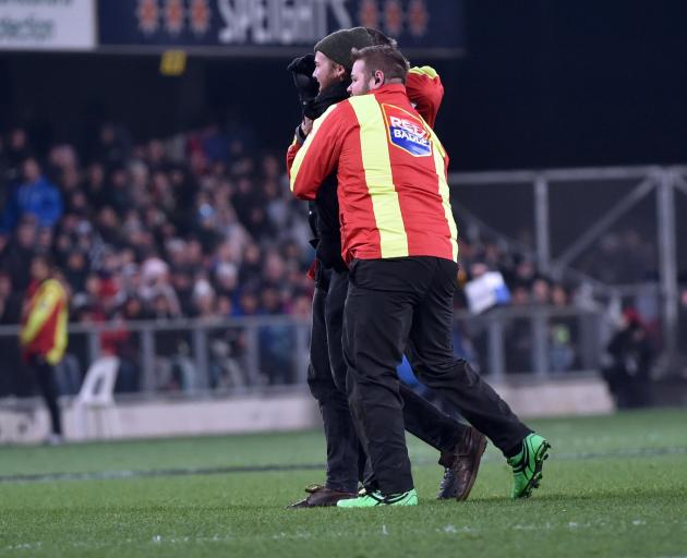 A Red Badge security guard walks a pitch invader off the field at an All Blacks test at Forsyth...