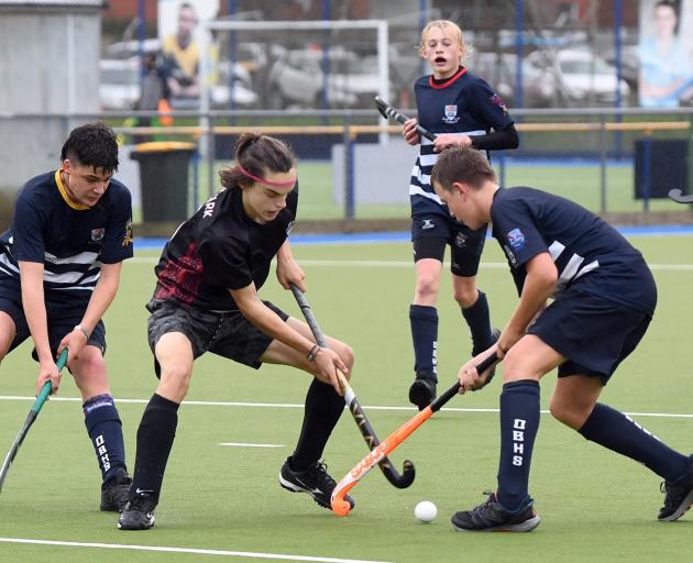 Logan Park High School hockey player Kieran Black (centre) tries to squeeze past two Otago Boys’...