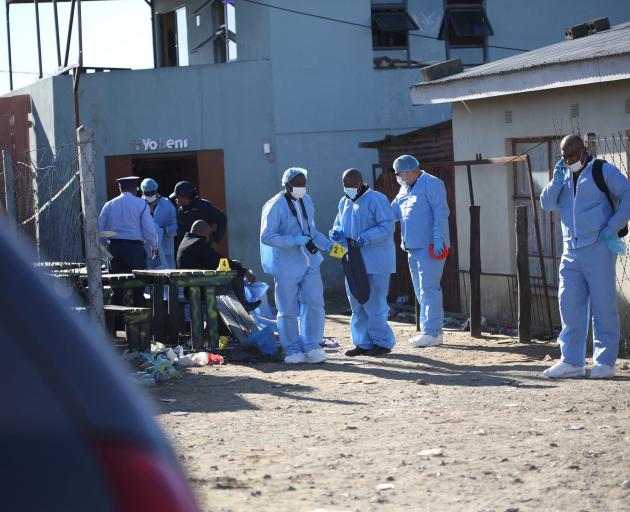 Forensic personnel outside the Enyobeni Tavern in Scenery Park. Photo: Reuters 