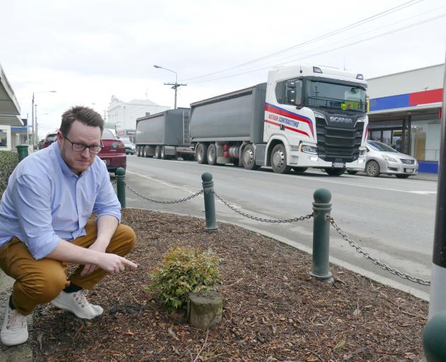 Framing Plus owner Chris McDonald points out a stump outside his business, adjoining a pedestrian...