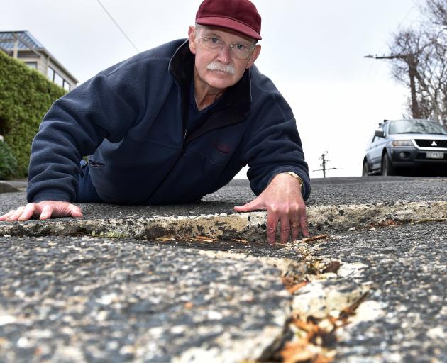 Daniel Knowles, of Challis St, shows a crack in his street which he says the council has failed...