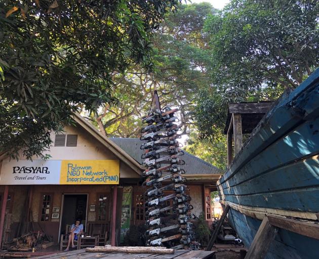 Bobby Chan and his chainsaw tower. A confiscated boat stands to the right.PHOTOS: KARL MALAKUNAS