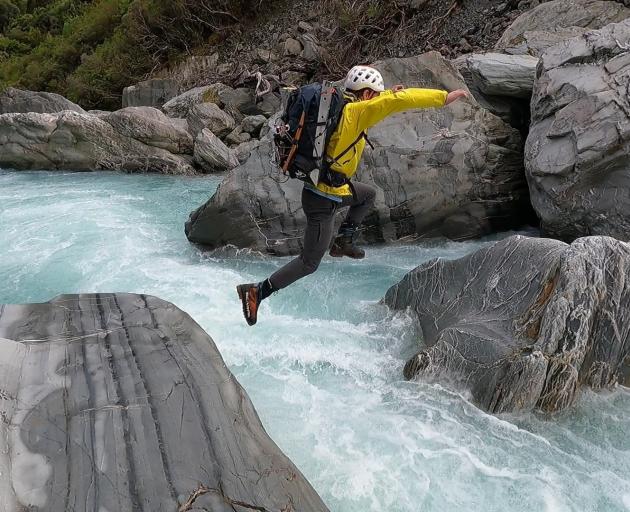 Hamish Fleming jumps across the Copland River.