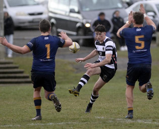 Southern first five Jack Leslie tries a chip kick between Dunedin forwards Kees Scott (left) and...