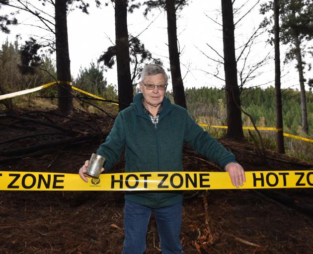 Holding an empty can found at the site of a fire on his Wingatui property is John Nelson, who...