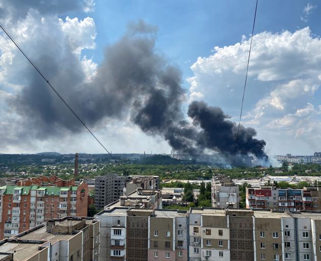 Smoke rises from the territory of an automotive centre following shelling in Donetsk. Photo:...