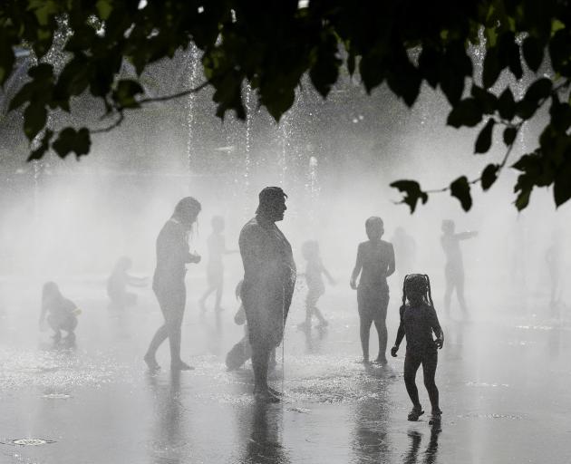 People try to cool off in a fountain in Madrid during the Spanish city's second heatwave of the...