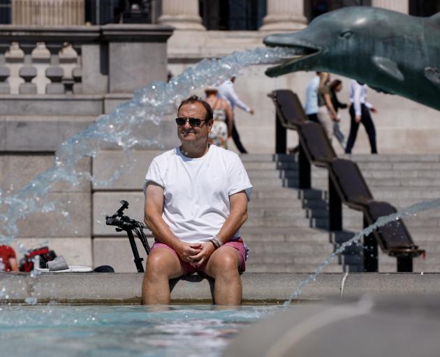 A man cools off in a fountain during the hot weather in London on Monday. Photo: Reuters 