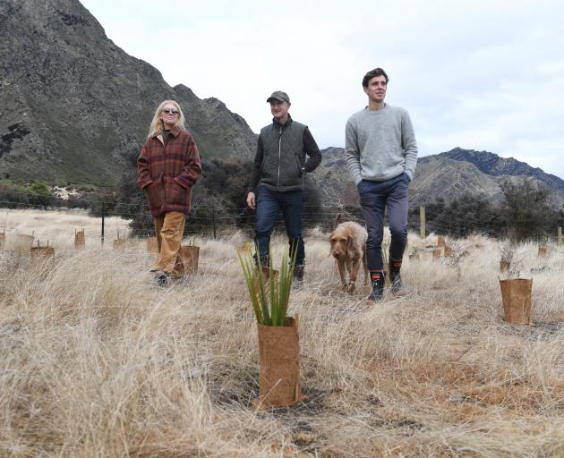Justine and Geoff Ross, their son Finn and Sika the dog, check native plantings on Lake Hawea...