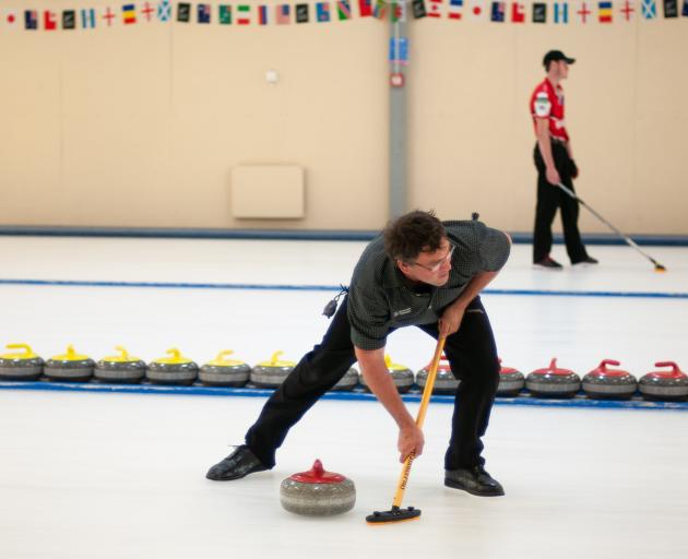 Sean Becker sweeps his stone on the second day of the New Zealand Curling mixed doubles qualifier...