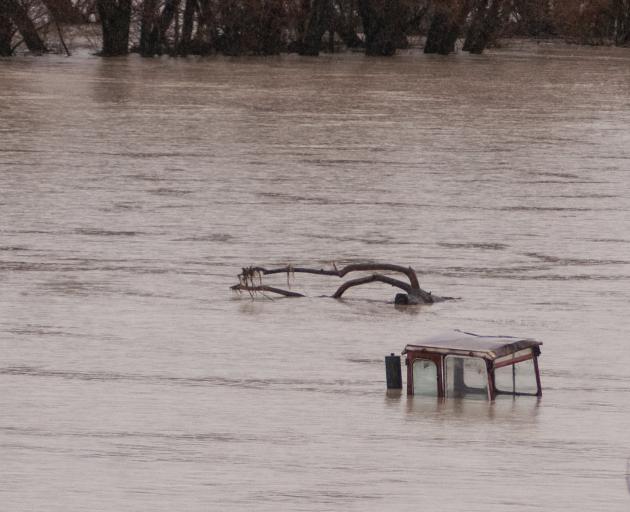 A tractor lies submerged in floodwater at Omakau. PHOTO: SHANNON THOMSON