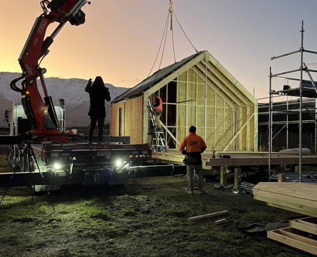 Construction workers from Makers Fabrication fit together the standardised panels built in their...