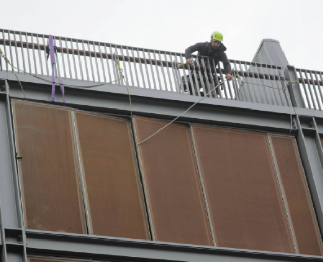 A worker tries to secure a panel on the outside of the Park Hyatt Hotel on Halsey St in Auckland....