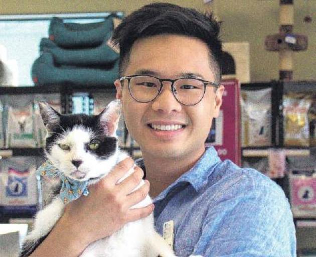 Veterinarian Cody Wong with his adopted ex-clinic cat, Stanley. Photo: Supplied