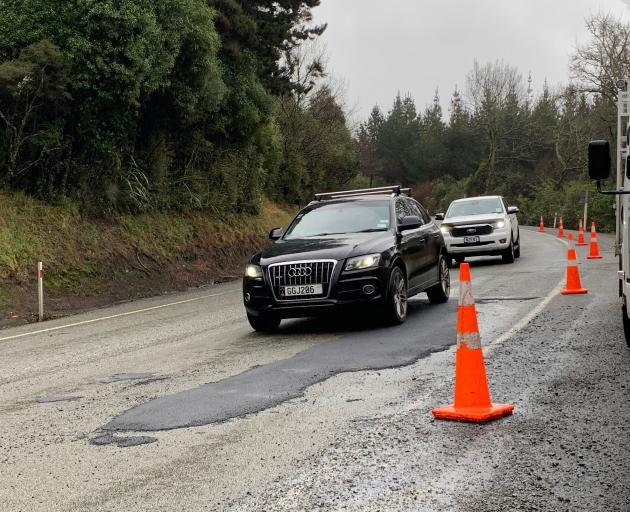 Motorists drive over a temporary fix for a pothole on the Northern Motorway (State Highway 1)...