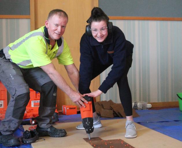 James Hargest College pupil Emma McNaught (16) learns from tradesman Chris Burns about how to lay...