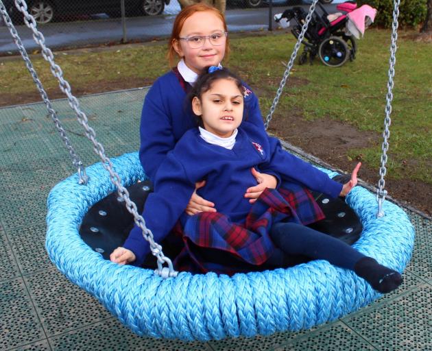 Pupil Ariana Percy (6) holds on to Latiya Haua Corkill-Smith (7) as they try out a new frisbee...