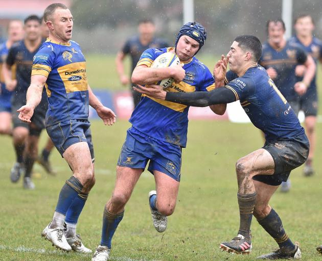 Taieri second five Brayden Laing tries to force his way through the tackle of Dunedin winger...