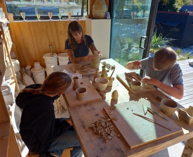 Pottery facilitator Shannon Courtenay (centre) guides Kahu Youth through making pottery pieces....