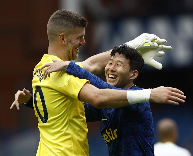 Tottenham Hotspur forward Son Heung-min (right) and goalkeeper Fraser Forster embrace after a pre...