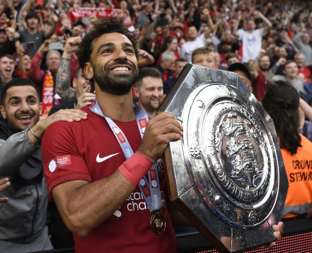 Liverpool forward Mohamed Salah celebrates with the trophy after his side’s Community Shield win...