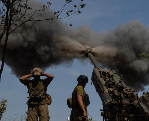 Ukrainian servicemen fire a M777 howitzer at a position on a front line, as Russia's attack on...