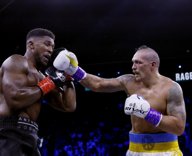 Oleksandr Usyk hits Anthony Joshua with a punch during his defence of the WBA, WBO and IBF...