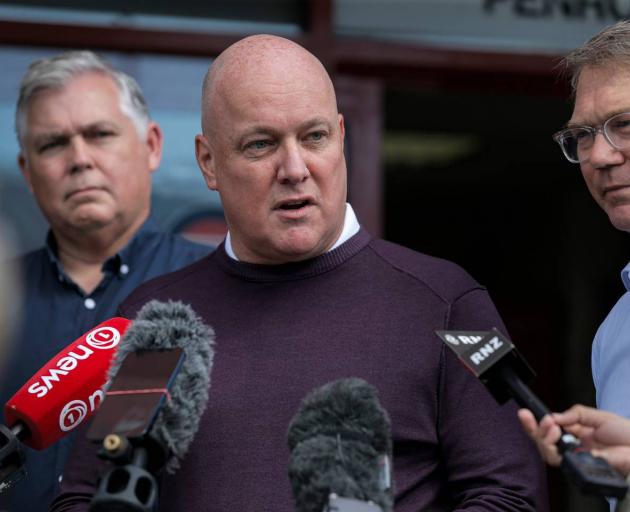 National Party leader Chistopher Luxon, flanked by police spokesman Mark Mitchell (left) and...