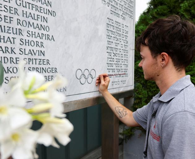 A stone cutter renovates a memorial stone for victims of the terrorist attack at the site in...
