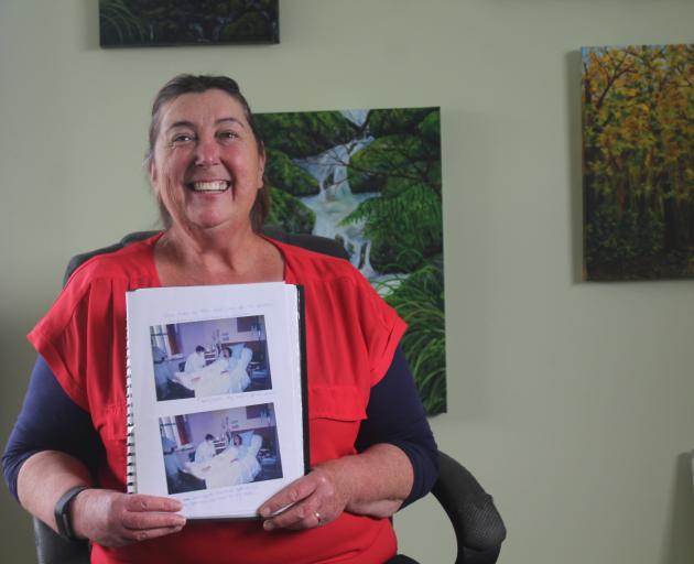Invercargill artist Kim Bungard (48) holds photos of herself taken after she received a heart...
