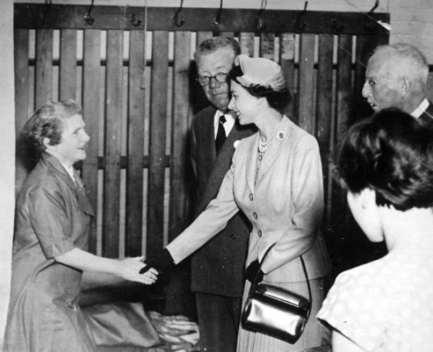 Queen Elizabeth II has a handshake and a smile for a member of the staff when she visited the...